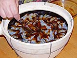 Spooning oyster sauce over prawns