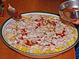 Sprinkling chilli sauce on vermicelli salad